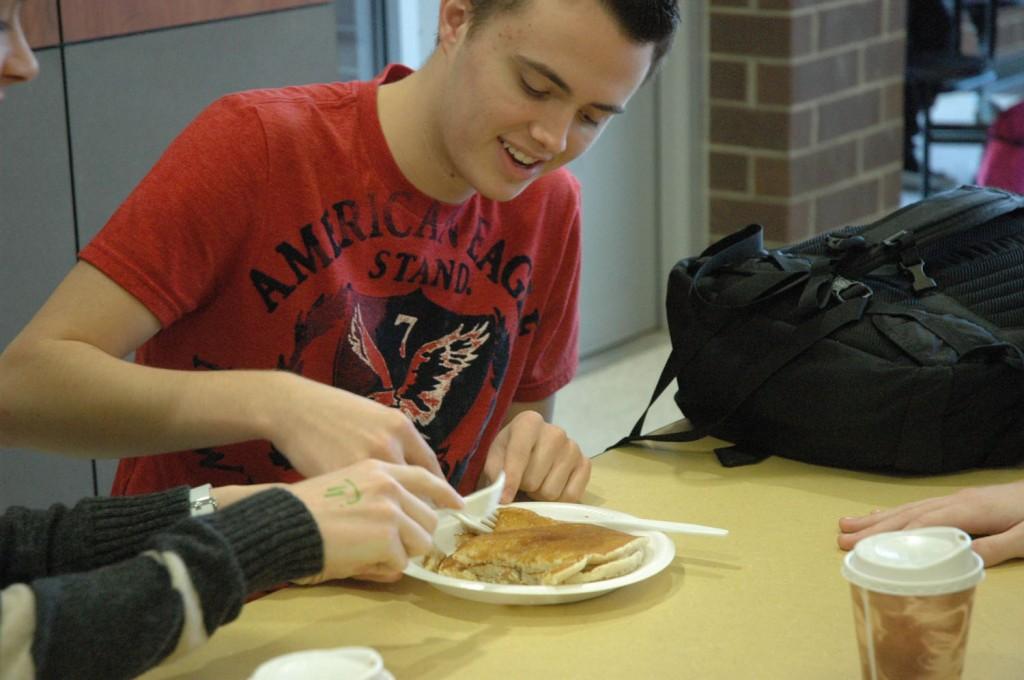 Sophomore Tyler Davis enjoys his pancakes during the Johnstons Big Give pancake breakfast. Pancakes were made by the Kiwanis club.