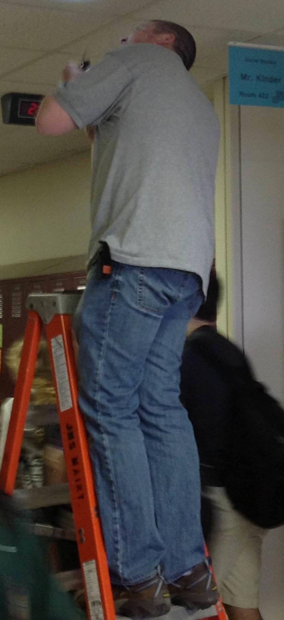 Custodian Jay Nickolash inspects the smoke detector after students were given the clear to come back into the school.
