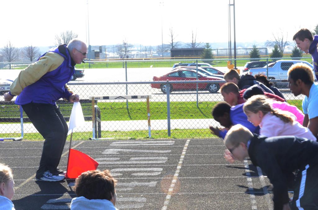 Dave Beason starts a heat of runners at the Little Dragon track meet on April 24. Participants ran a 100 meter dash and after the race could see their name and time on the scoreboard.