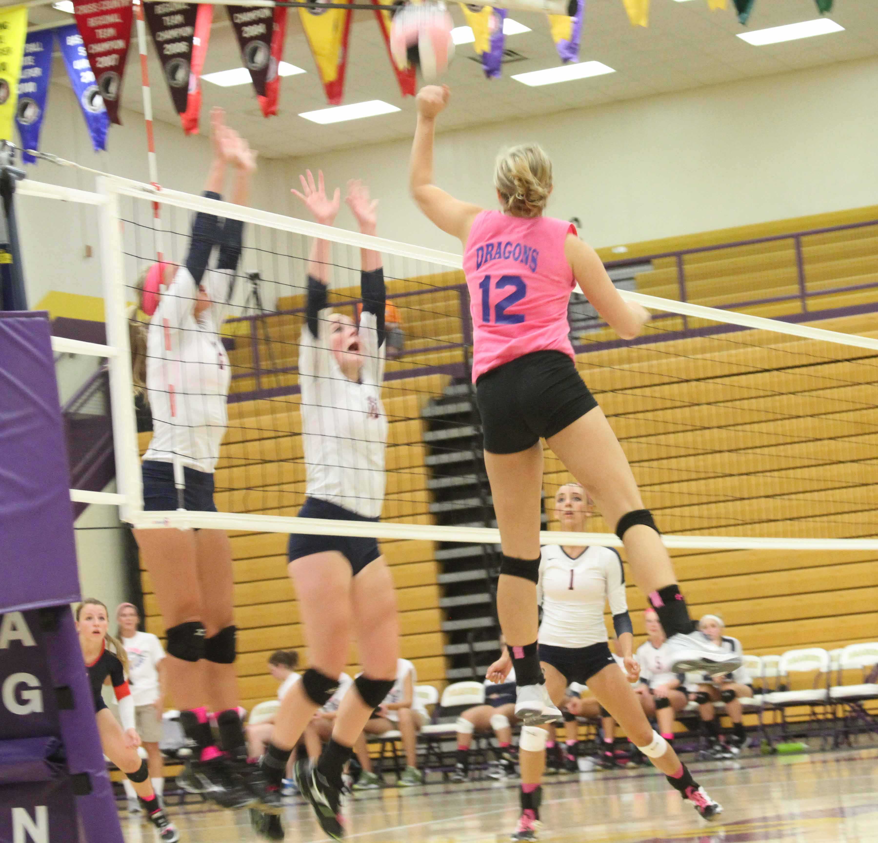 Senior Madeline Miller jumps up to spike the ball during the first set of Dig Pink Spike Blue. After playing five games, Johnston fell to Urbandale in extra points with a score of 17-15.