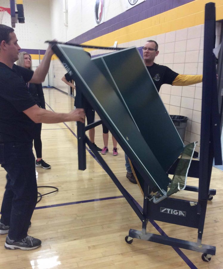 The faculty members are picking up the broken table and are taking it out of the room. The table broke 8th period in Deb Nicholsons PE class Friday 27, 2017. 