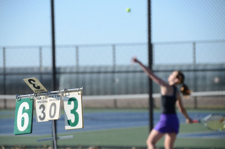 Junior Emma Grace Walter serves the ball into the wind in the meet against Ankeny. The Dragons won both the meet against Ankeny and against North.