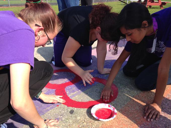 Juniors (from left to right) Analea Couture, Alisha Giesselmann and Michelle Kumar help repaint the GSAs stadium painting.