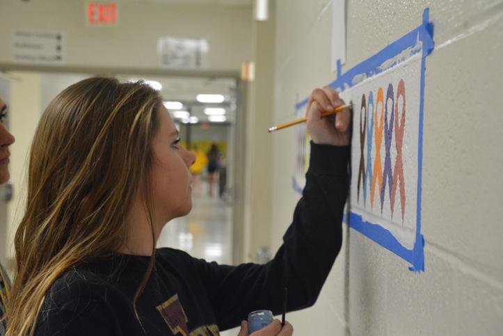 Painting+a+new+mural+in+the+art+room+hallway%2C+senior+Addie+Bolles+hopes+to+raise+awareness+for+the+different+cancers.