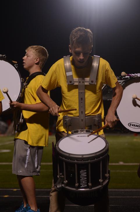 Senior Ross Kromminga hits the snare drum with the drumline next to the field. The band scored Superior for their performance at state.
