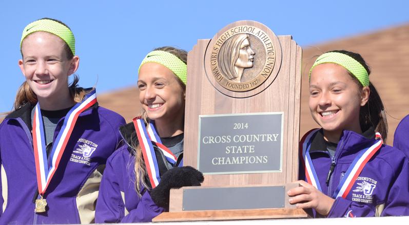 Seniors Jordyn Kleve and Sandra Kromminga, along with junior Sara Ness hold up their state champion trophy after winning the state meet Nov. 1. This is the first state title in the girls cross country history. Kleve ran a time of 14:14, which is the fastest in Johnston history. 