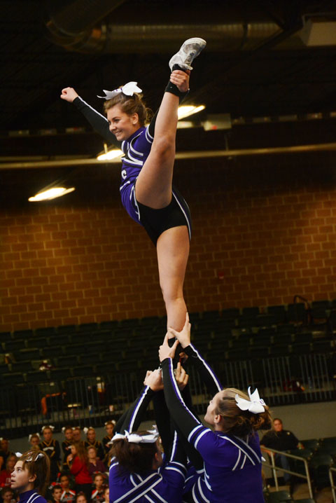The bases lift up freshman Baylie Bucher during a stunt for the varsity performance. The varsity competition team is the only cheer team heading off to nationals.
