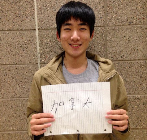 Junior Michael Tan holds a sign that says 'Canadian' in traditional Chinese characters to represent his identity in both cultures.