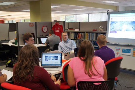 Students from the DCS strand of CAPS, listen to a worker from DLR (the company that shares their office space with the DCS program) as he goes over market strategies. In the beginning of the term, the students were given the task of creating their own personalized workspace. DLR happily complied and worked with the students to create the best learning environment for everyone in the office.
