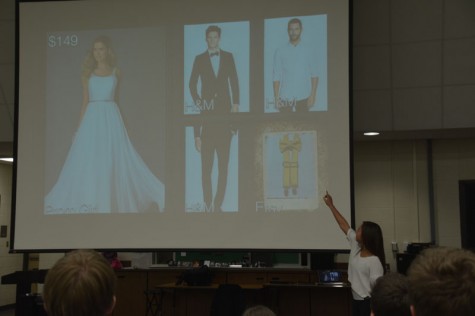 Senior Michaela Davis gestures to the projection screen, where the costumes she selected for her show choir project are displayed. As part of the annual project, students have to create their own show choir show, complete with music, themes, and costumes.
