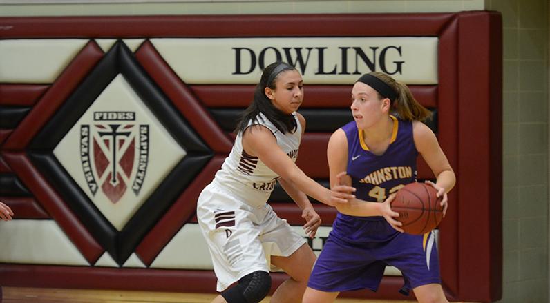 Senior Rachel Hinders dodges a Dowling player during their game before the varsity boys Dec. 11. The girls kept up their undefeated streak 6-0, after winning the game 51-42. 