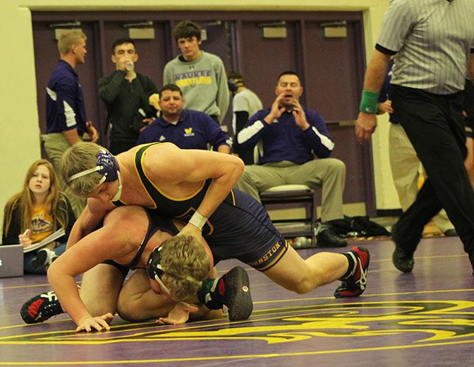 Senior Ben Wilson attempts to pin down his Waukee opponent. Dragons won 34-20 against the Warriors Jan. 7.