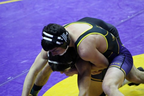 During the state wrestling meet Feb. 17, senior Ethan Ksiazek attempts to bring down his opponent from S.E.Polk. Ksiazek competed during state individuals with a sprained ankle and dislocated shoulder. Ksiazek still managed to place fourth in state finals for the 132 pound weight class.