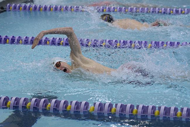 Swimming the 200 yard individual medley, senior Zach Smith takes a breath. The boys swim team placed second in the District swim meet Feb. 6. 