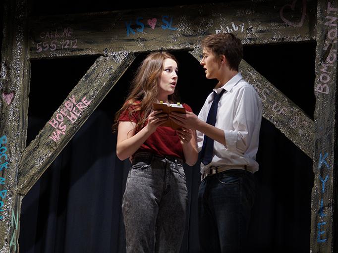 Standing by the Patawney Bridge where Ariels brother passed away, Ariel played by senior Sarah Henry helps out Ren played by senior Seth Tack, pick out verses from the Bible to use at the town hall meeting. Students performed Footloose April 22, 23 and 24 in the auditorium. 