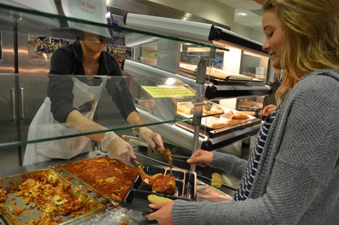 Senior Lizzy Salmon serves lasagna to senior Lizzy Orr as part of her Culinary 3 assignment. The Culinary 3 class provided lasagna, tiramisu and chocolate cake as a lunch option April 8.