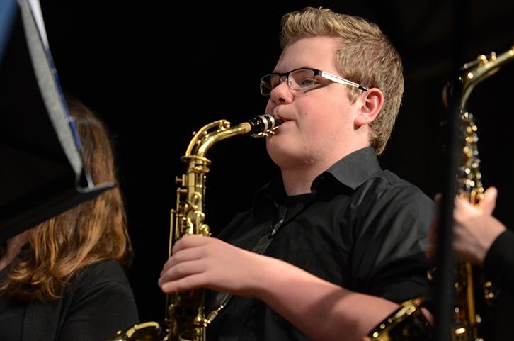 Playing on the alto saxaphone junior Charles Charlie Hoekstra focuses during the prime of their final song. Both Concert and Wind Symphony band had their last concert on May 16 at the middle school.