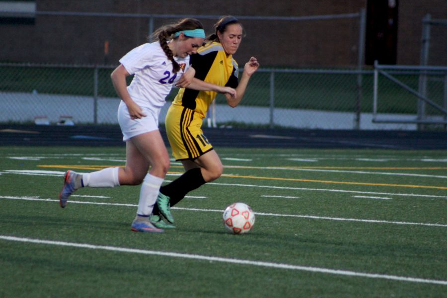 Senior Sam Birmingham tries to keep possession of the ball against S.E. Polk. The girls varsity team is 13-4 with their last loss coming to Waukee May 24. 