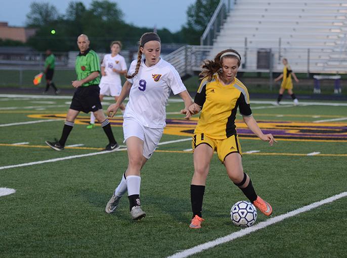 Working to defend the Dragons side of the field senior Shayna Stubbs studies a way to get the ball. The Dragons played against the Rams May 10 winning 2-1.