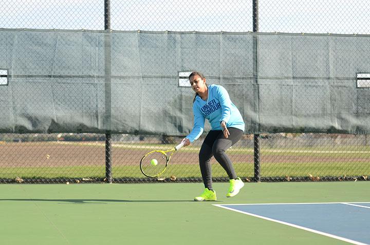 Returning a serve, senior Sabritha Chandler hits the ball. Freshman Cari Naanep and Sophomore Bell Hoppenjans won the district meet in doubles May 19. 