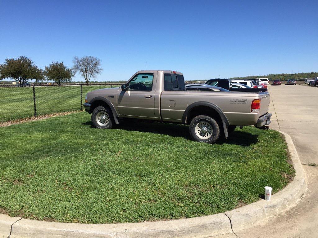 A student parks their car on the grass after no spots were left in the tennis court parking lot. Senior Alec Wray captured the moment and posted the photo on Twitter.