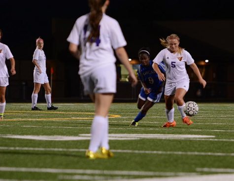 Sophomore Tayler Caffrey dribbles the ball up the felid as senior Ruth Boland of Marshalltown attempts to win the ball. The team has a record of 9-2 on the season.