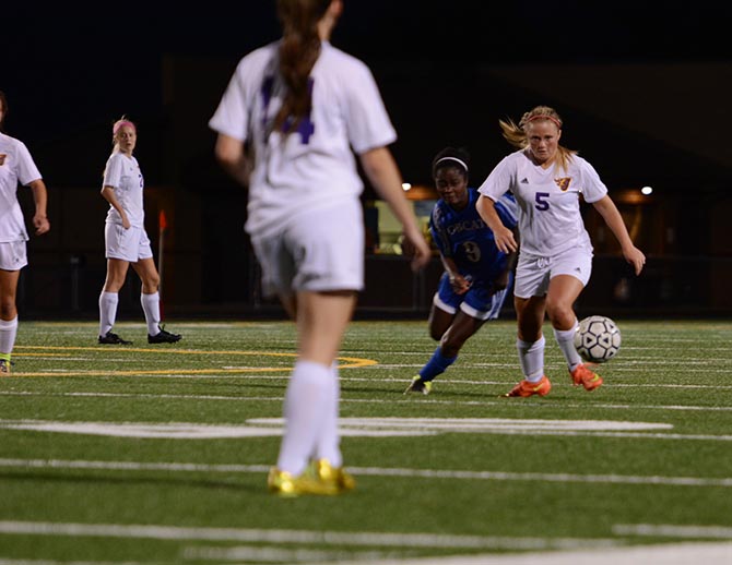 Sophomore Tayler Caffrey dribbles the ball up the felid as senior Ruth Boland of Marshalltown attempts to win the ball.  The team has a record of 9-2 on the season. 