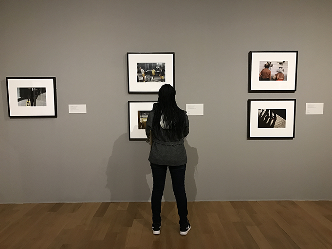 A student stands before a wall of Vivian Maier photos. Students in art classes had the opportunity to see the exhibit Nov. 15 on a field trip.