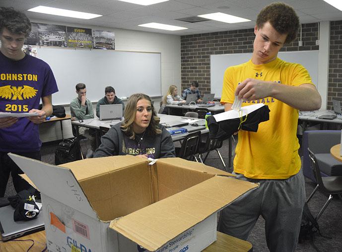Jack Dreyer ‘17 and Alex Dougherty ‘17, sort the “Roll Drags“ shirts out by size. The shirts will be handed out in time for the Johnston versus Urbandale basketball game Dec.16.