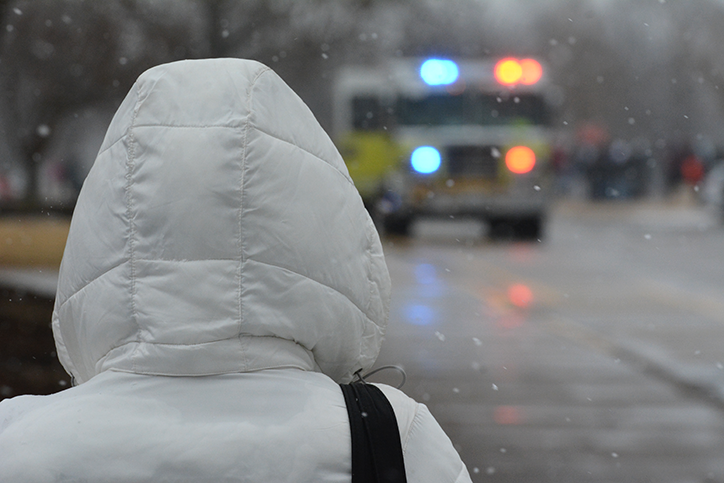 A student looks to the fire truck as it pulls up to investigate the fire alarm. The fire alarm went off during B Lunch, sending students and staff outside into the snow.                                                                                                                          