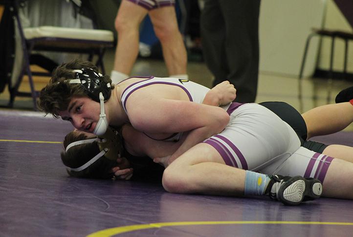 Elliot+Pholmeyer+takes+control+over+an+opponent+while+checking+how+much+time+is+left+in+the+period.+Pholmeyer+wrestles+in+the+152+pound+weight+class.