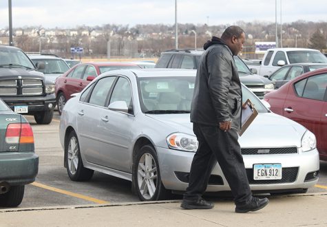 Dannie walks around the parking lot checking cars for parking tags. He checks the lot in sections because of the size.