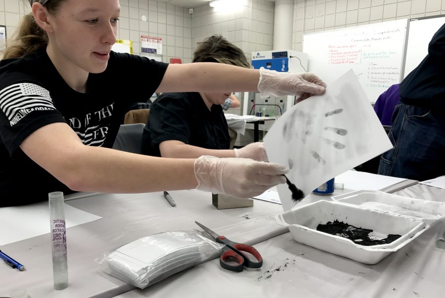 Jessica Orman 17 brushes magnetic powder to reveal her hand print. Students in DMACCs criminal justice program participate in labs every Thursday and Friday over material covered throughout the week.