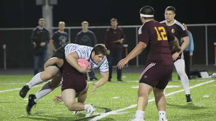 Diving over an Ankeny opponent, Bryce Rowland ‘17 attempts to keep hold of the ball.  The rugby team lost to Ankeny 21-0 April 14.