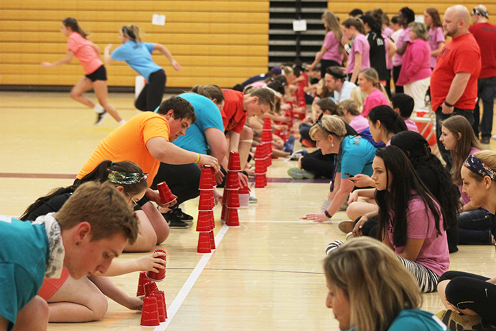 Seniors from different teams line up to stack cups while their advisors and judges watch. For the event each member of a team was required to stack 15 cups in a five, four, three, two, one order then unstack them.