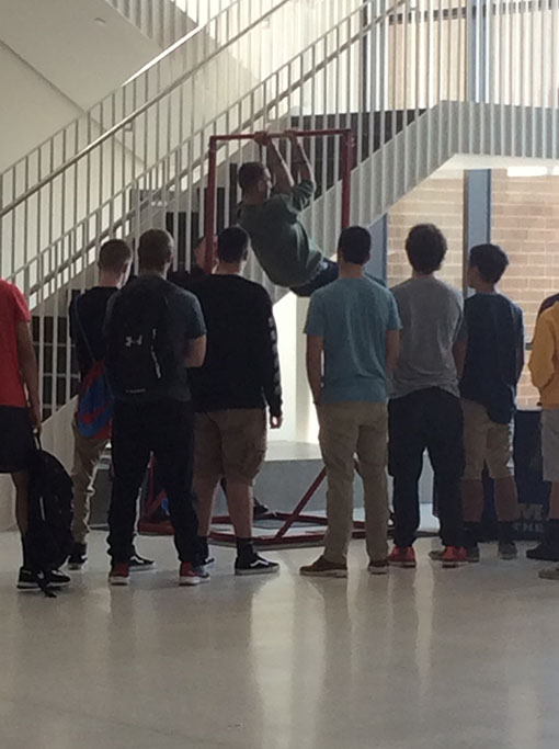 Students line up to attempt to do as many pull ups as they can.