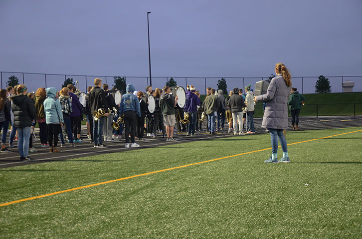 Libbie Smith 18 holds the long range speaker as the band practices marching on the track. The band had early morning practice everyday starting at seven during the marching band season.