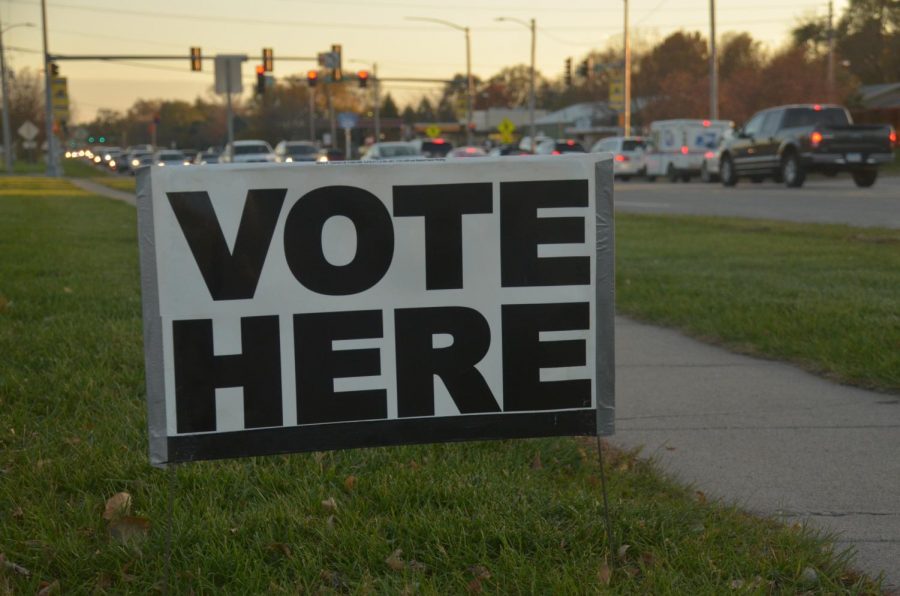 Vote Here sign placed on the side of Merle Hay Road, on the lawn, in front of City Hall to grab the attention of those driving by.