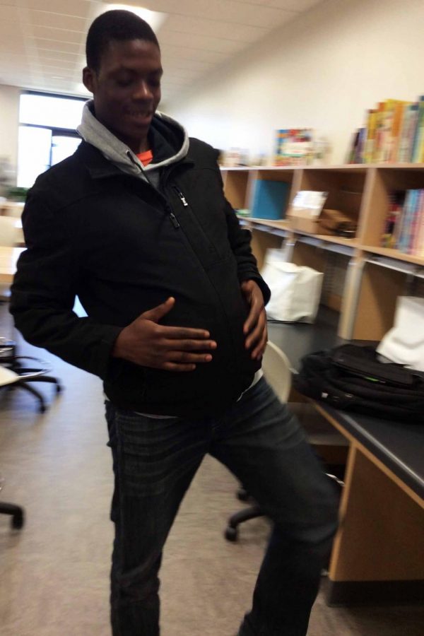 Kalambayi Ntambwe '18 demonstrates his mobility with the empathy belly by doing a suggested exercise activity. Physical activity is necessary for a pregnant mother in order to keep balance and reduce back pain.