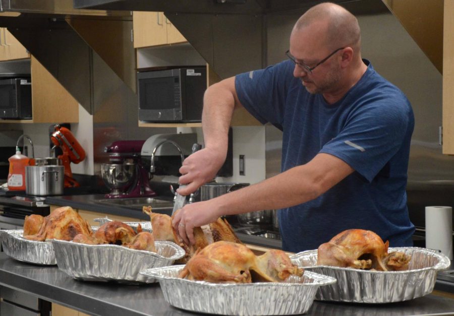 Chad Thoreson cuts the turkey for students to take home. He was in charge of the seven turkeys in addition to cooking the thanksgiving turkey for the Thoreson family dinner.