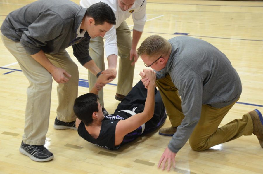 An injured Boston Grimes 18, pulls himself up with the assistance of the coaches. Grimes was injured during the first period. He recovered and continued playing the rest of the game. 