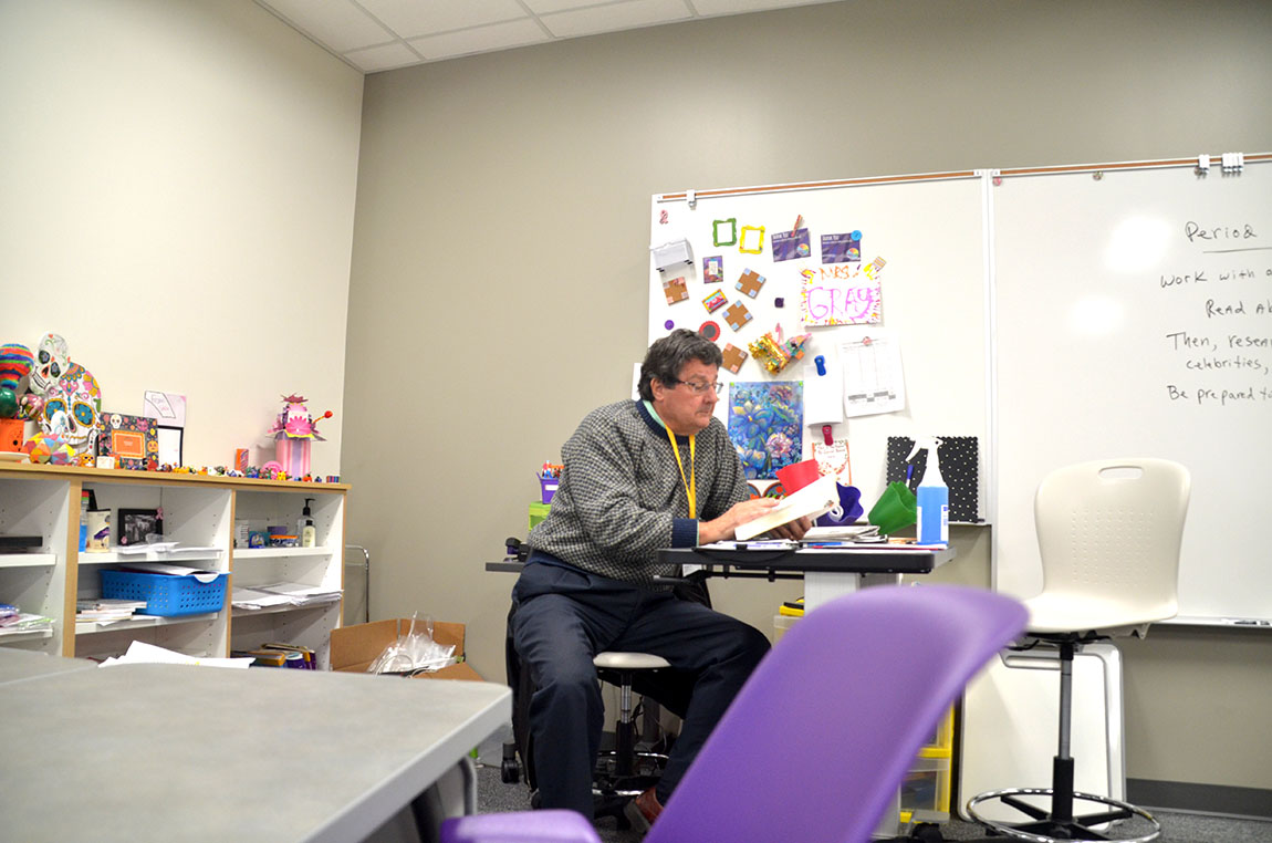 Substitute Bruce Demsky reads a Spanish dictionary while substituting for Kari Gray's French I class.