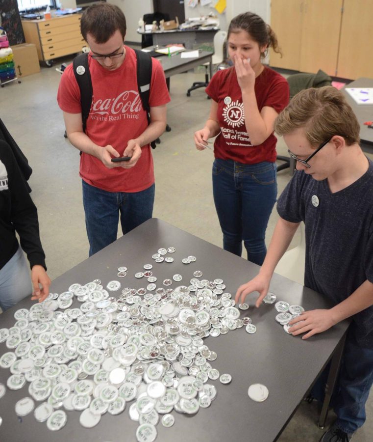 Dylan Ritter ‘18 counts out how many buttons were made during the three hours of work. The total reached over 550, not couting the buttons already taken by everyone who worked to make them.