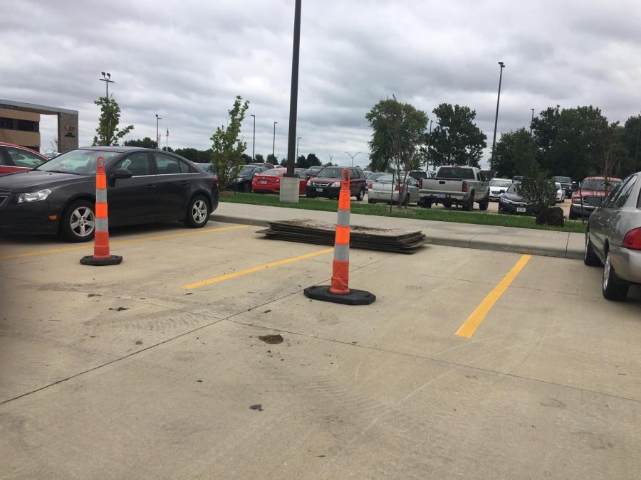 Cones and planks blocked off two parking spaces so that parking signs could be installed. 