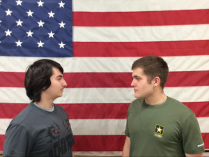 A marine and an army recruit face off in front of the American flag
