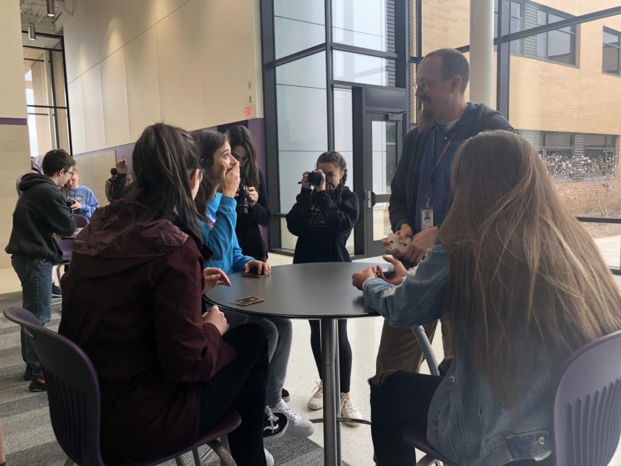 Art teacher Andrew McCormick teaches digital photography students how to play various card games while others take portrait photos of them.