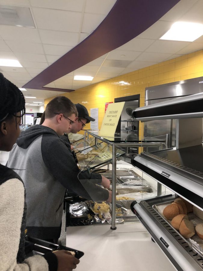 Students wait in line to get pasta from the pasta bar.
