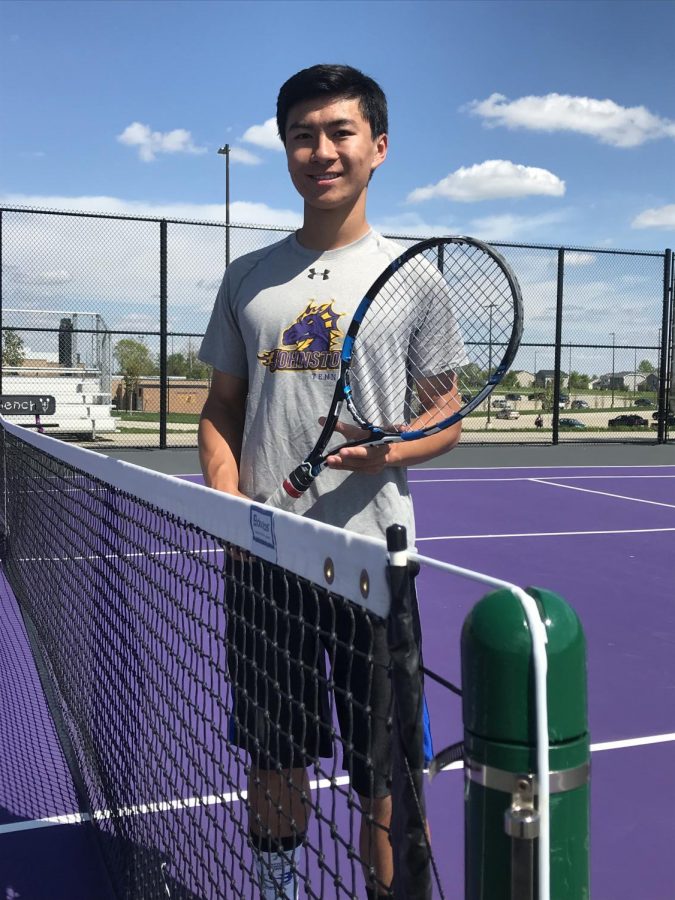 Chris Yao 19 holds his tennis racket on the Johnston tennis courts.