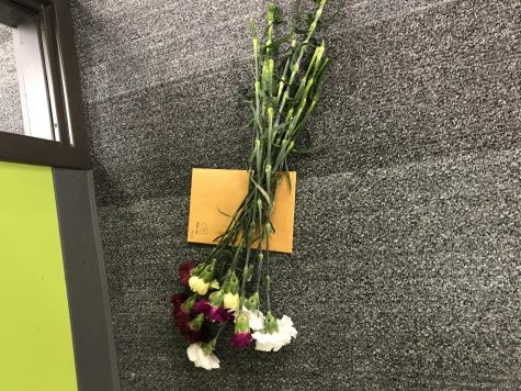 A group of carnations and notes are waiting to be received by a teacher.