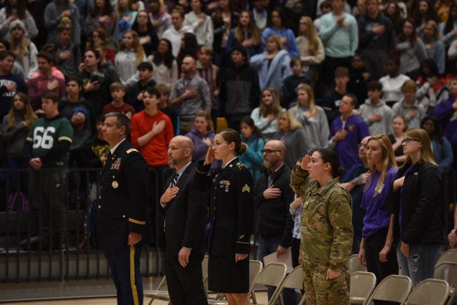 Recruiter Ashley Zerwas and Raichel Beierle '20 
saluting the flag during the national anthem.